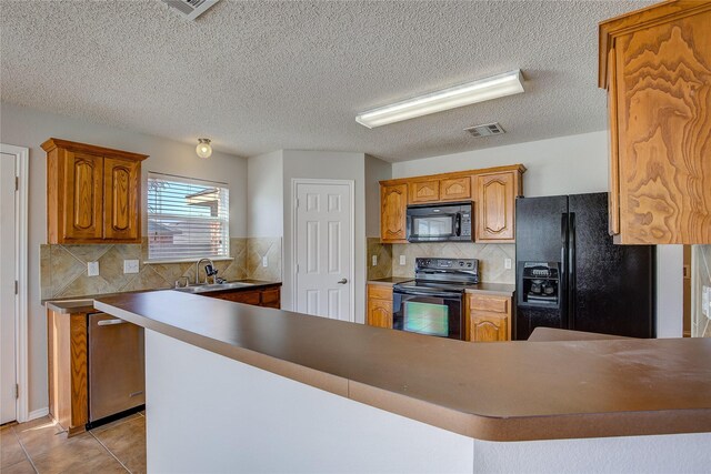 kitchen featuring light tile patterned floors, decorative backsplash, a sink, visible vents, and black appliances