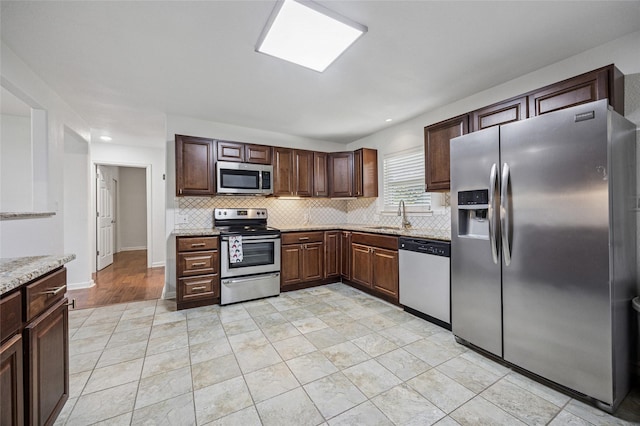 5609 Fursman Ave, Fort Worth, TX 76114 - kitchen featuring stainless steel appliances, tasteful backsplash, a sink, light stone counters, and recessed lighting
