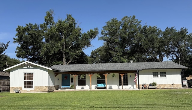 1704 S Houston St, Kaufman, TX 75142 - ranch-style house featuring stone siding, board and batten siding, a front yard, roof with shingles, and a porch