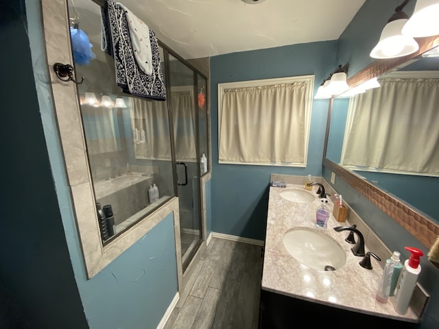 1704 S Houston St, Kaufman, TX 75142 - bathroom featuring double vanity, a stall shower, wood finished floors, and baseboards