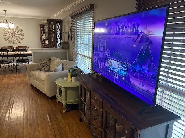 1704 S Houston St, Kaufman, TX 75142 - living area with healthy amount of natural light, wood finished floors, a chandelier, and ornamental molding
