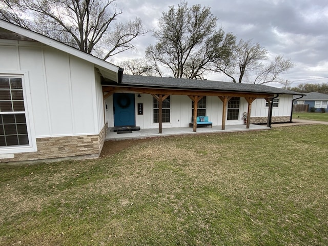 1704 S Houston St, Kaufman, TX 75142 - view of front of home featuring board and batten siding, stone siding, a front yard, and a porch