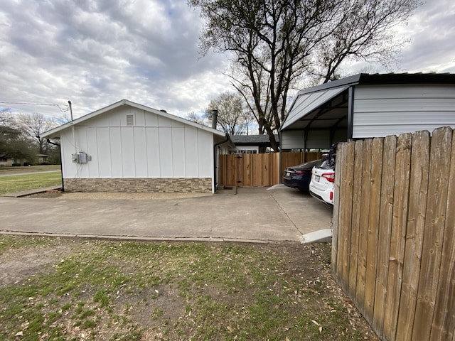 1704 S Houston St, Kaufman, TX 75142 - view of side of home with stone siding, a carport, and concrete driveway