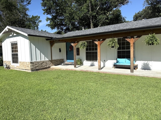 1704 S Houston St, Kaufman, TX 75142 - view of front of house featuring a front lawn, stone siding, board and batten siding, and roof with shingles
