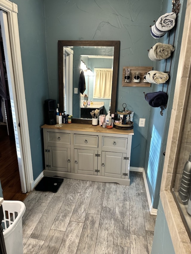 1704 S Houston St, Kaufman, TX 75142 - full bath with wood finished floors, vanity, and baseboards