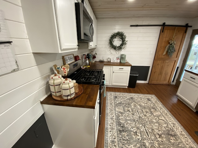 1704 S Houston St, Kaufman, TX 75142 - kitchen featuring appliances with stainless steel finishes, butcher block countertops, white cabinets, and dark wood finished floors