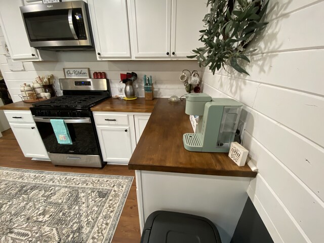 1704 S Houston St, Kaufman, TX 75142 - kitchen featuring butcher block countertops, stainless steel appliances, and white cabinetry