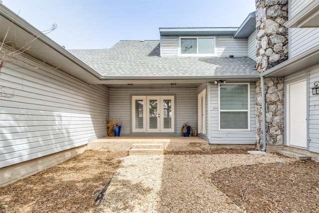 entrance to property featuring roof with shingles and french doors
