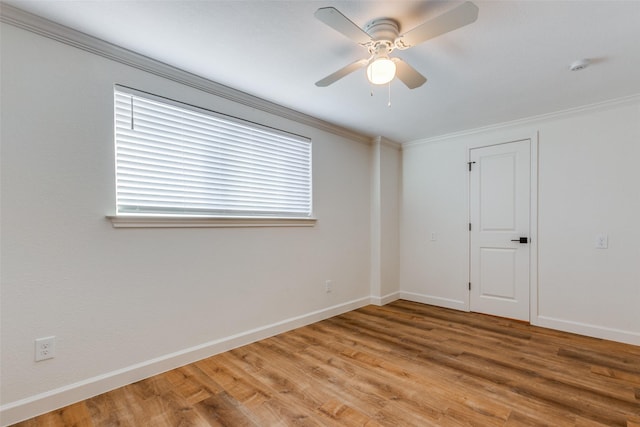 empty room featuring light wood-type flooring, crown molding, baseboards, and a ceiling fan