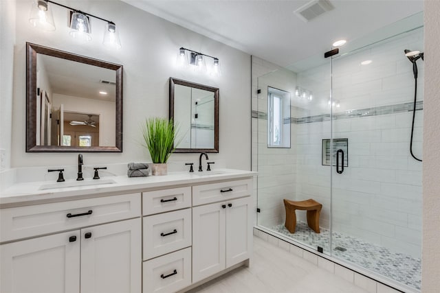 full bath with a sink, visible vents, a shower stall, and double vanity