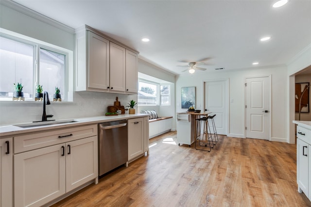 kitchen with crown molding, decorative backsplash, dishwasher, a sink, and ceiling fan
