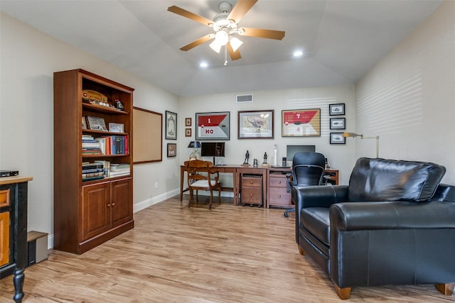 office featuring light wood-style floors, vaulted ceiling, a ceiling fan, and visible vents