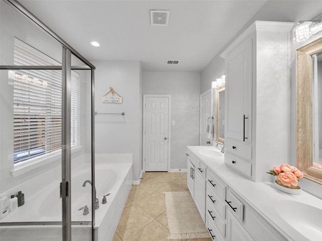 7601 Glenwood Springs Ln, Mckinney, TX 75070 - bathroom featuring a sink, double vanity, tile patterned floors, visible vents, and a garden tub