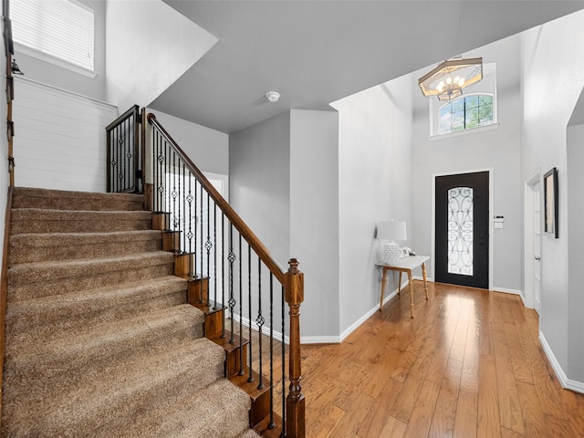 7601 Glenwood Springs Ln, Mckinney, TX 75070 - entrance foyer with stairway, a chandelier, a high ceiling, light wood finished floors, and baseboards