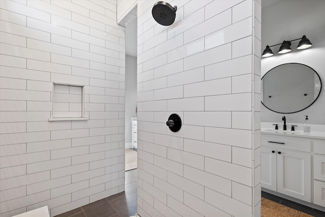 bathroom featuring tile patterned flooring, vanity, and a walk in shower