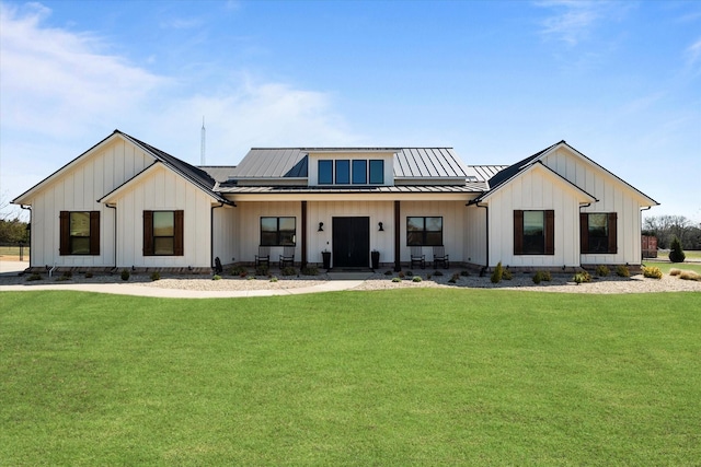view of front of house with board and batten siding, a front yard, and a standing seam roof