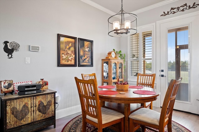 dining area featuring baseboards, an inviting chandelier, wood finished floors, and crown molding