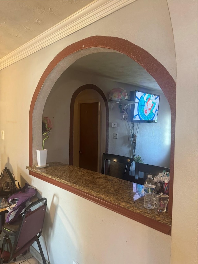 hallway with crown molding and arched walkways