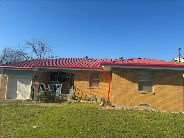 exterior space with metal roof, brick siding, an attached garage, and a yard