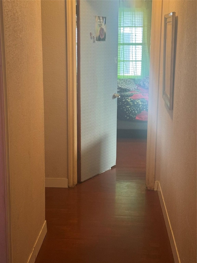 hall with wood finished floors and baseboards