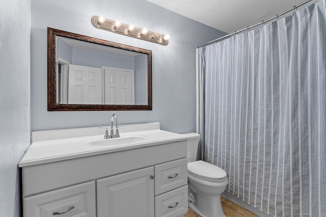 full bath featuring vanity, a shower with shower curtain, a textured ceiling, tile patterned floors, and toilet