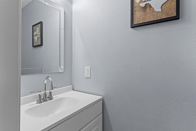 bathroom featuring vanity and a textured wall