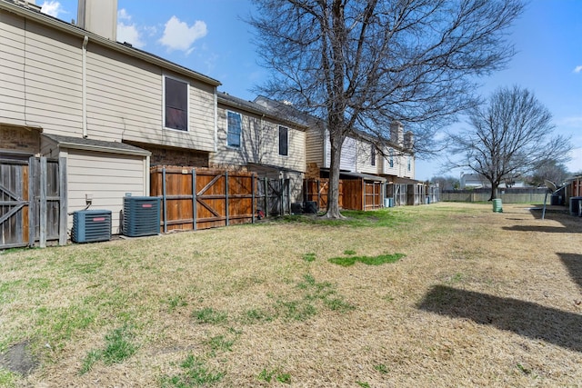 view of yard featuring central AC unit and fence