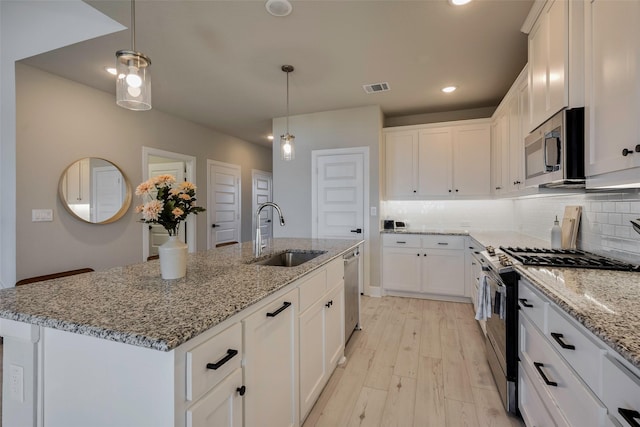 kitchen with visible vents, a sink, white cabinetry, and appliances with stainless steel finishes