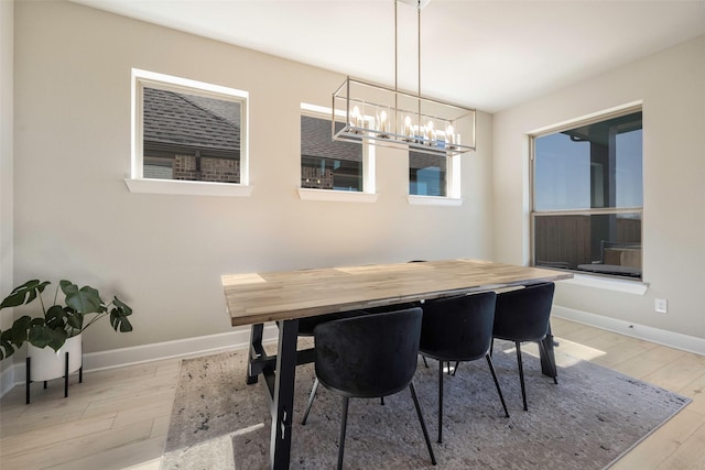 dining room featuring an inviting chandelier, wood finished floors, and baseboards