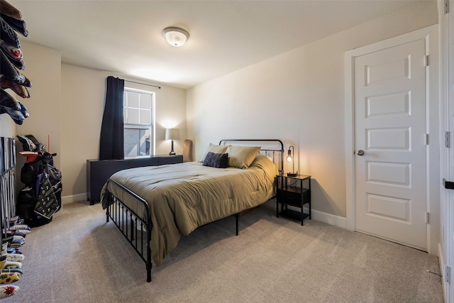 bedroom featuring baseboards and light colored carpet