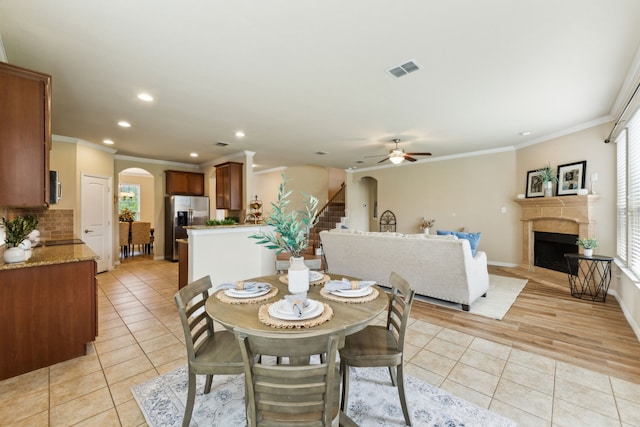 1605 Tahoe Trl, Prosper, TX 75078 - dining space featuring arched walkways, a fireplace, stairs, recessed lighting, and light tile patterned flooring