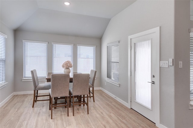 dining area with a wealth of natural light, light wood-type flooring, and vaulted ceiling