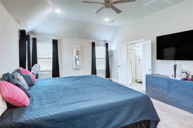 bedroom with visible vents, lofted ceiling, light carpet, and ensuite bathroom