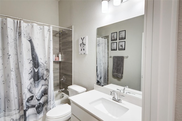 bathroom with vanity, toilet, a textured wall, and shower / bath combo