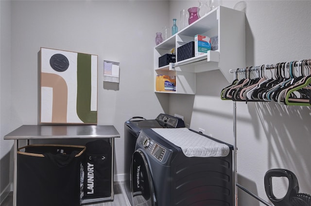 laundry area with washer and dryer, wood finished floors, and laundry area