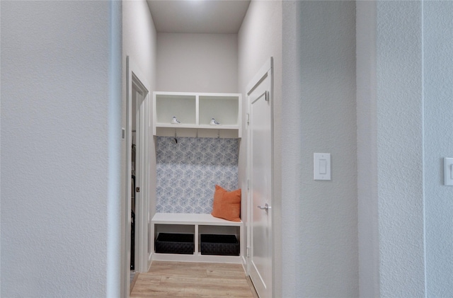 mudroom featuring wood finished floors and a textured wall