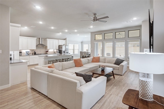 living room featuring recessed lighting, a ceiling fan, and light wood finished floors