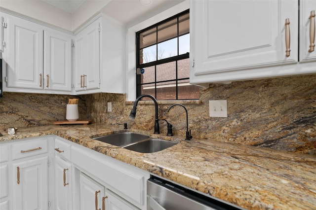 kitchen featuring dishwasher, white cabinets, and a sink