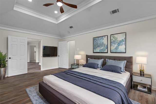 bedroom featuring visible vents, a raised ceiling, wood finished floors, and crown molding