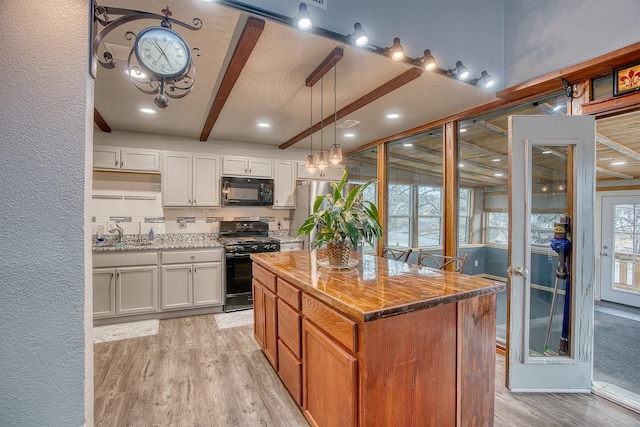 237 Runaway Bay Dr, Runaway Bay, TX 76426 - kitchen featuring decorative backsplash, beamed ceiling, visible vents, light wood-style floors, and black appliances
