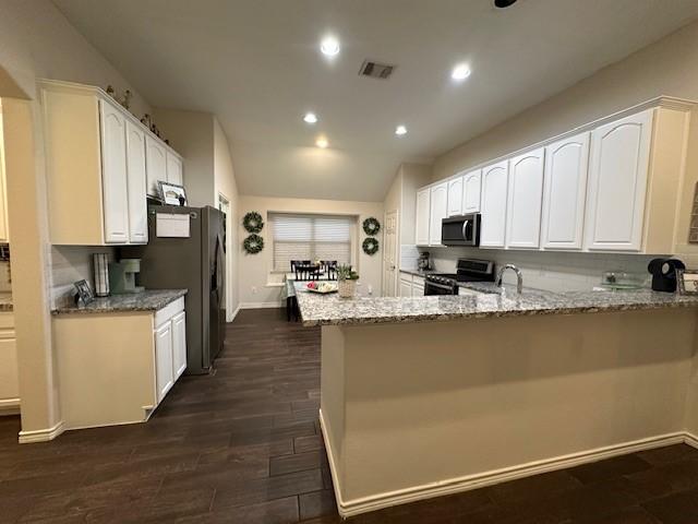 1615 Summerfield Dr, Allen, TX 75002 - kitchen with appliances with stainless steel finishes, light stone counters, white cabinets, a peninsula, and recessed lighting