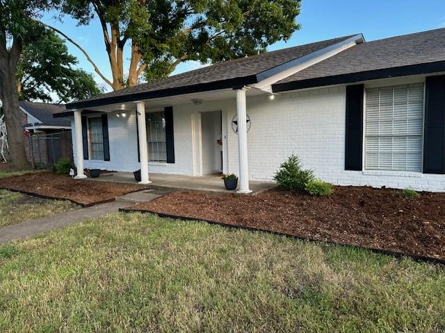 2612 Lemmontree Ln, Plano, TX 75074 - ranch-style house featuring a porch, brick siding, a front lawn, and roof with shingles