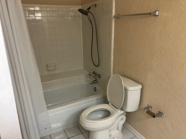2612 Lemmontree Ln, Plano, TX 75074 - full bathroom with tile patterned floors, shower / bath combo with shower curtain, a textured wall, toilet, and baseboards