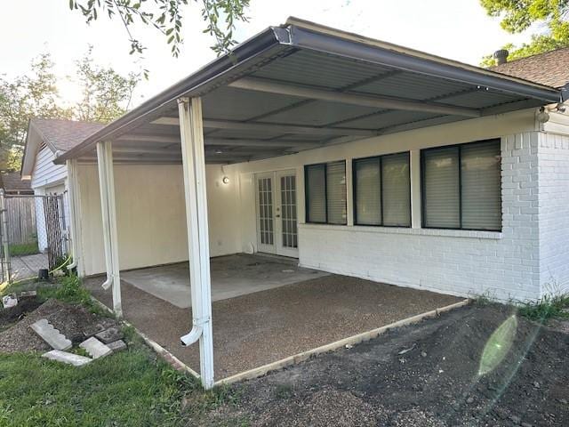 back of house with french doors, brick siding, and fence