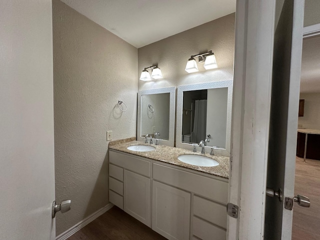 2612 Lemmontree Ln, Plano, TX 75074 - full bath with a textured wall, double vanity, baseboards, and wood finished floors