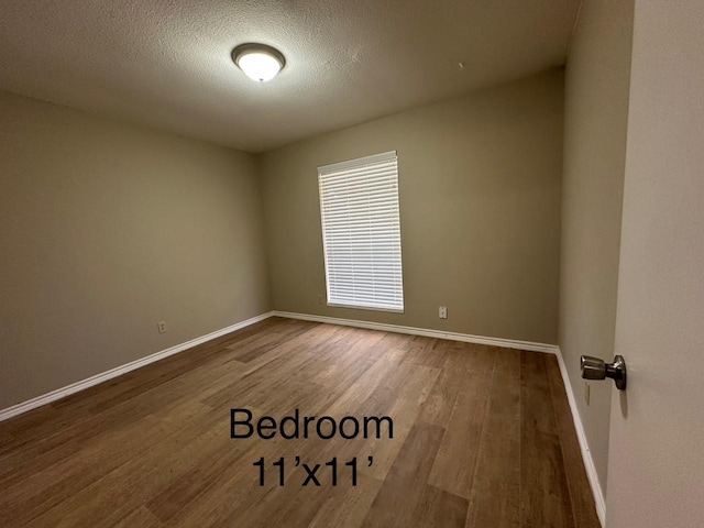 2612 Lemmontree Ln, Plano, TX 75074 - spare room featuring baseboards, wood finished floors, and a textured ceiling