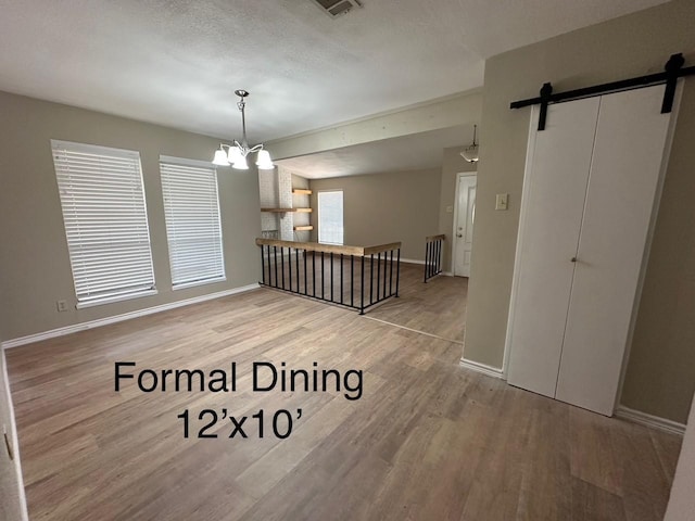 2612 Lemmontree Ln, Plano, TX 75074 - unfurnished dining area with a barn door, wood finished floors, a chandelier, and baseboards