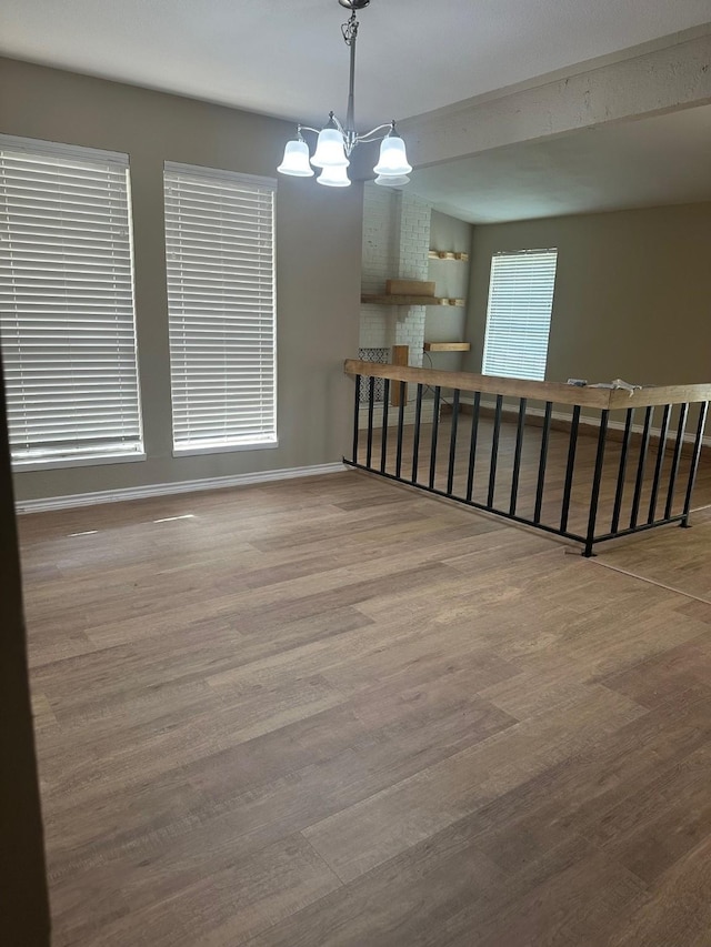 2612 Lemmontree Ln, Plano, TX 75074 - empty room with wood finished floors, a chandelier, and baseboards