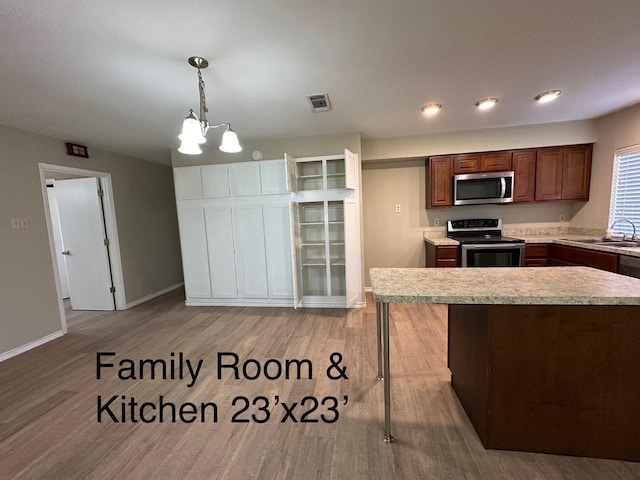 2612 Lemmontree Ln, Plano, TX 75074 - kitchen with stainless steel appliances, a sink, light countertops, a chandelier, and wood finished floors