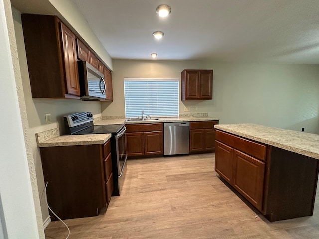 2612 Lemmontree Ln, Plano, TX 75074 - kitchen featuring stainless steel appliances, light wood-style floors, a sink, and light countertops